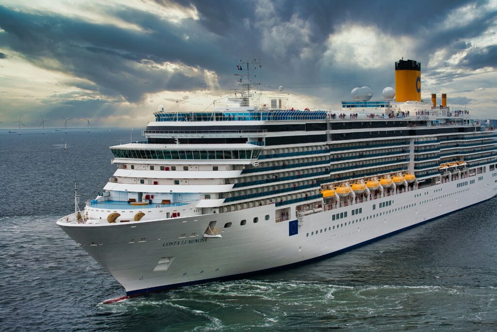 Large cruise ship sailing on the ocean under dramatic cloudy skies